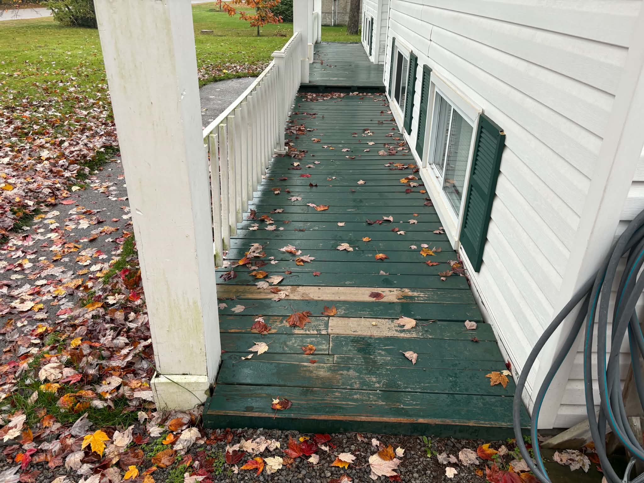A worn green porch before PMK rebuilt it