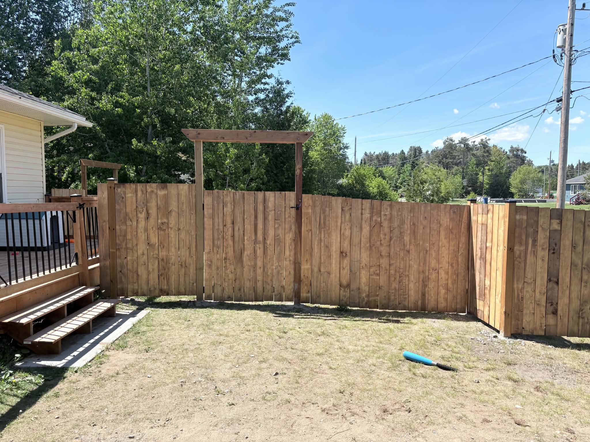 Completed wood privacy fence with two custom gates built by PMK Construction